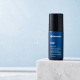 Elemental NUR Desert Rain roll-on natural deodorant on white marble with water droplets