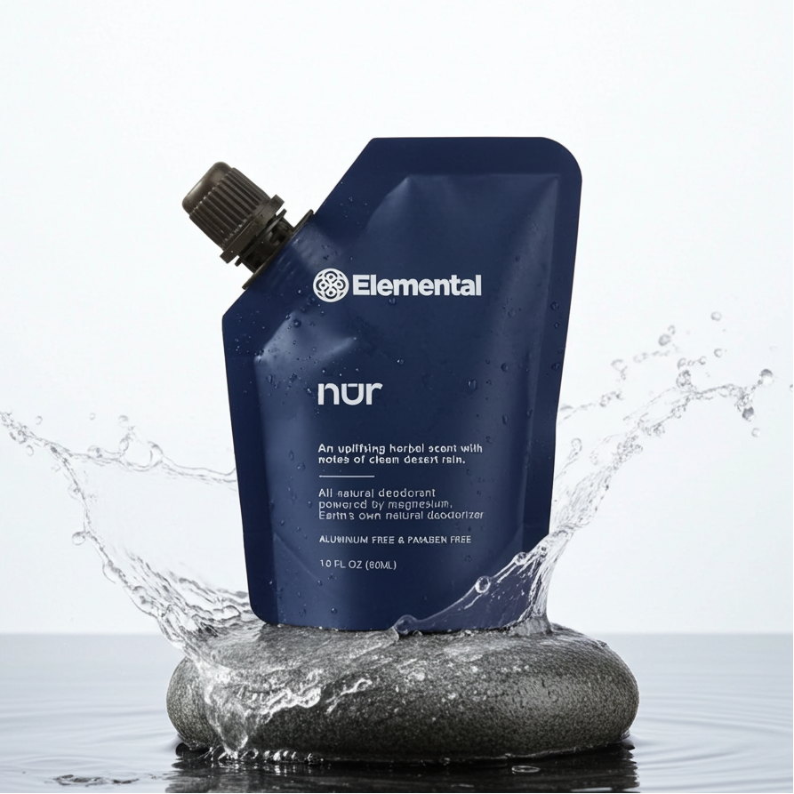 Blue Elemental 'nur' deodorant pouch with water splash on a light gray background